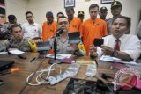 Polisi mengawasi tiga warga Turki, Ulvi Turker (kanan), Hikmet Azturk (kedua kanan) dan Ali Riza Gorsoy yang berupaya membobol rekening bank, dalam konferensi pers di Mapolresta, Denpasar, Jumat (30/12/2016). Polisi menangkap ketiga warga Turki tersebut setelah berupaya membobol rekening nasabah bank dengan memasang alat perekam data (skimmer) di mesin ATM. (ANTARA/Nyoman Budhiana)
PreviousNext
