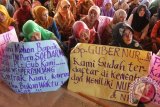 Sejumlah guru kontrak dari SD dan SMP yang tergabung dalam Barisan Guru Bersatu Aceh membentangkan poster saat aksi di kantor gubernur Aceh, Banda Aceh, Jumat (30/12). Mereka mendesak pemerintah pusat dan pemerintah Aceh mengalokasikan dana untuk guru kontrak yang terancam putus kontrak, serta menolak keras implementasi UU nomor 23 tahun 2014 jika bertujuan memisahkan pengelolaan dan penyelenggaraan pendidikan dasar oleh pemerintah kota dan provinsi. (ANTARA Aceh/Ampelsa)