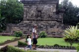 Pengunjung mengamati relief di Candi Badut , Malang, Jawa Timur, Minggu (1/1). Libur tahun baru dimanfaatkan masyarakat dengan mengajak anak-anak mengunjungi candi badut untuk mengenalkan peninggalan purbakala sekaligus berwisata. Antara Jatim/Ari Bowo Sucipto/zk/16.