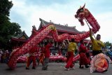 Wisatawan menyaksikan atraksi liong di kompleks Klenteng Sam Poo Kong, Semarang, Jawa Tengah, Minggu (1/1/2017). Klenteng Sam Poo Kong merupakan salah satu destinasi di Semarang yang banyak diminati wisatawan. (ANTARA FOTO/R. Rekotomo)