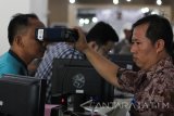 Petugas melakukan perekaman retina warga yang mengurus e-KTP kependudukan di kantor Dinas kependudukan dan Catatan Sipil Kota Surabaya, Jawa Timur, Selasa (3/1). Seluruh kantor pelayanan publik kembali melayani masyarakat setelah libur tahun baru 2017. Antara Jatim/Didik Suhartono/zk/17