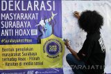 Warga membubuhkan tanda tangan di atas spanduk bertuliskan Deklarasi Masyarakat Surabaya Anti Hoax di Surabaya, Jawa Timur, Minggu (8/1). Kegiatan tersebut bertujuan memberikan penjelasan kepada warga tentang ciri-ciri konten Hoax di dunia maya serta bahayanya dengan mengajak warga untuk lebih berhati-hati dalam menerima informasi yang kurang jelas sumbernya. Antara Jatim/Didik Suhartono/zk/17