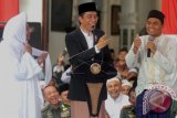 Presiden Joko Widodo (tengah) berbincang dengan seorang santri disaksikan Ketua Jam'iyyah Ahlith Thoriqoh al-Mutabarah al-Nahdliyyah (JATMAN) Habib Muhammad Luthfi bin Yahya (kiri) pada peringatan Maulid Nabi Muhammad SAW, di Pekalongan, Jawa Tengah, Minggu (8/1). Presiden berpesan kepada santri untuk lebih selektif dalam memilh informasi melalui media sosial yang berkaitan dengan kebencian dan SARA. ANTARA FOTO/Harviyan Perdana Putra/wdy/17.