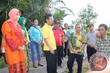 Bupati Barito Kuala, Kalimantan Selatan H. Hasanuddin Murad bersama istri Hj. Normiliyani didampingi Kadis Kesehatan Batola Sugian Nor, Camat Mandastana Suyud Sugiono, Kepala Puskesmas Laila Wardani dan kades setempat. Mengunjungi  penderita tumor Ahmadi, warga Desa Puntik Luar Kecamatan Mandastana, Minggu (8/1). Foto:Antaranews Kalsel/Arianto/G.