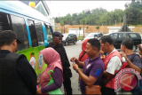 Sejumlah masyarakat berbaris di mobil kas keliling BI di area PLBN Entikong untuk menukar uang baru Tahun Emisi 2016 pada Rabu (11/1). (Foto Antara Kalbar/ Dedi)