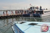 Sejumlah wisatawan berjalan di dermaga untuk berwisata dengan kapal laut di Serangan, Denpasar, Jumat (13/1). Bali menargetkan pemberdayaan pelabuhan laut yang bisa mengakomodasi kapal pesiar sehingga dapat meningkatkan kunjungan wisatawan di tahun 2017 yaitu sebanyak 5,5 juta orang dari sebelumnya 4,4 juta orang pada tahun 2016. ANTARA FOTO/Nyoman Budhiana/wdy/17.