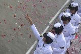 Sejumlah anggota Korps Wanita Angkatan Laut menabur bunga ke laut saat upacara peringatan Hari Dharma Samudera di atas geladak KRI Makassar-590, Surabaya di Dermaga Koarmatim Ujung Surabaya Jawa Timur, Minggu (15/1). Peringatan tersebut untuk mengenang arwah dan jasa para pahlawan laut yang gugur pada pertempuran Laut Aru 15 Januari 1962. Antara Jatim/Zabur Karuru/zk/17