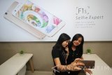 Dua orang SPG berswafoto menggunakan ponsel cerdas Oppo F1s disela pembukaan toko dan pusat servis Oppo di WTC E-Mall, Surabaya, Jawa Timur, Senin (16/1). Pembukaan toko dan pusat servis Oppo yang baru di Kota Surabaya tersebut bertujuan untuk memberikan kenyamanan dan kecepatan pelayanan kepada pengguna ponsel cerdas merk Oppo. Antara Jatim/Moch Asim/zk/17