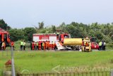 Sejumlah petugas mengevakuasi bangkai pesawat latih yang gagal landing di Bandara Blimbingsari, Banyuwangi, Jawa Timur, Senin (16/1). Pesawat latih Sekolah Pilot Mandiri Utama Fligh Academy (MUFA) jenis pesawat Cesna 172S yang dikendarai oleh Siswi Regina Martalia tersebut, mengalami gagal landing dan terbakar saat latihan terbang di Bandara Blimbingsari Banyuwangi. Antara Jatim/Budi Candra Setya/zk/17.