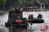 Presiden Joko Widodo (tengah) didampingi Panglima TNI Jenderal TNI Gatot Nurmantyo (kiri) dan Kapolri Jenderal Pol Tito Karnavian (kanan) menyeberangi danau menggunakan kendaraan Panser Anoa 2 6x6 Amphibious sebelum memimpin rapat pimpinan TNI di Mabes TNI, Cilangkap, Jakarta, Senin (16/1). Rapim itu mengangkat tema 'Bersama Rakyat TNI Kuat, Hebat, Profesional serta Siap Melaksanakan Tugas Pokok'. ANTARA FOTO/Akbar Nugroho Gumay/wdy/17.