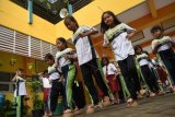 Sejumlah siswa SD memainkan permainan tradisional egrang batok kelapa di SDN Bubutan IV Surabaya, Jawa Timur, Senin (16/1). Berbagai permainan tradisional seperti egrang, dakon, egrang batok kelapa, jaranan pelepah pisang dan patil lele diajarkan kepada anak-anak usia dini untuk memperkenalkan kembali permainan tradisional yang kini jarang dijumpai. ANTARA FOTO/M Risyal Hidayat/aww/17.