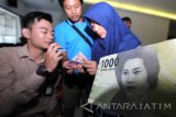 Petugas Bank Indonesia (BI) mensosialisasikan desain uang baru di Kantor Bupati Banyuwangi, Jawa Timur, Kamis (19/1). Kegiatan tersebut, selain mensosialisasikan desain uang baru juga untuk menepis isu hoak yang beredar diantaranya, tentang gambar pahlawan, kesamaan dengan mata uang Yen dan adanya logo palu arit. Antara Jatim/Budi Candra Setya/zk/17. 