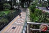 Warga melintas di jalur pedestrian di area Kebun Raya Bogor, Kota Bogor, Jawa Barat, Kamis (19/1). Proyek pembangunan trotoar untuk pedestrian dan jalur sepeda di seputar Kebun Raya dan Istana Bogor telah selesai dikerjakan. (ANTARAFOTO/Yulius Satria Wijaya).