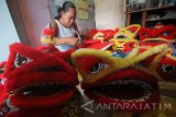 Perajin menyelesaikan pembuatan kerajinan barongsai mini di Surabaya, Jawa Timur, Senin (23/1). Mendekati Tahun Baru Imlek 2568, permintaan kerajinan barongsai mini berbahan limbah kertas bekas yang dijual dengan harga mulai Rp75.000 hingga Rp400.000 per buah tersebut mengalami peningkatan sampai tiga kali lipat dibandingkan dengan hari biasanya Antara Jatim/Moch Asim/zk/17