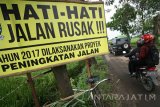 Pengendara melintas di jalan yang kondisinya rusak di desa Guyangan, Nganjuk, Jawa Timur, Kamis (26/1). Jalur utama yang diperuntukkan bagi angkutan barang dari Madiun ke Kediri tersebut terpaksa dialihkan karena kondisinya rusak berat sejauh kurang lebih 5 km. Antara Jatim/Prasetia Fauzani/zk/17