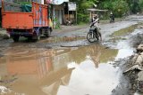 Pengendara melintas di jalan yang kondisinya rusak di desa Guyangan, Nganjuk, Jawa Timur, Kamis (26/1). Jalur utama yang diperuntukkan bagi angkutan barang dari Madiun ke Kediri tersebut terpaksa dialihkan karena kondisinya rusak berat sejauh kurang lebih 5 km. Antara Jatim/Prasetia Fauzani/zk/17