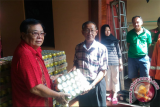 Ateng Tanjaya saat menyerahkan minuman kaleng pada salah satu ketua Yayasan Damkar Kota Pontianak dalam rangka menyambut perayaan Imlek 2568 pada 28 Januari 2017 . (Foto Antara Kalbar / Slamet Ardiansyah)