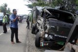 Seorang pria mengamati truk yang hancur dilokasi kecelakaan truk militer menabrak truk barang bermuatan material besi bangunan dari arah satu jalur di lintasan jalan nasional, Desa Aneuk Galung, Kabupaten Aceh Besar, Aceh, Minggu (29/1). Akibat kecelakaan tersebut, dua mobil truk militer bermuatan drum berisi bahan bakar solar ringsek dan truk barang bermuatan besi bangunan rusak, sementara lima penumpang dan termasuk supir dan satu pengemudi sepeda motor mengalami luka ringan dan luka serius dirawat di rumah sakit setempat. ANTARA FOTO/Ampelsa/pd/17