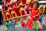 Seorang anak memainkan boneka barongsai yang dijual di Kota Singkawang, Kalbar, Jumat (27/1). Boneka Barongsai yang dapat dimainkan anak-anak saat perayaan Imlek dan Cap Go Meh tersebut, dijual seharga Rp150 ribu hingga Rp250 ribu per buah sesuai ukuran. ANTARA FOTO/Jessica Helena Wuysang/17


