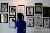 Pengunjung melihat poster karikatur tokoh dunia dan nasional yang dipamerkan dalam pameran desain grafis di Gedung Dewan Kesenian Malang, Jawa Timur, Senin (30/1). Pameran desain grafis bertajuk Sikats tersebut berlangsung selama seminggu dengan menampilkan puluhan seni inatalasi, poster karikatur dan gambar ilustrasi karya seniman muda. Antara Jatim/Ari Bowo Sucipto/zk/17