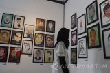 Pengunjung melihat poster karikatur tokoh dunia dan nasional yang dipamerkan dalam pameran desain grafis di Gedung Dewan Kesenian Malang, Jawa Timur, Senin (30/1).  Pameran desain grafis bertajuk Sikats tersebut berlangsung selama seminggu dengan menampilkan puluhan seni inatalasi, poster karikatur dan gambar ilustrasi karya seniman muda. Antara Jatim/Ari Bowo Sucipto/zk/17