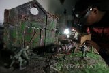 Perajin membuat kerajinan diorama Perang Dunia II di Surabaya, Jawa Timur, Senin (30/1). Kerajinan diorama dengan berbagai tema cerita yang dapat dipesan sesuai keinginan konsumen tersebut dijual dengan harga Rp500.000-Rp6.000.000 tergantung ukuran dan tingkat kesulitannya. Antara Jatim/Didik Suhartono/zk/17