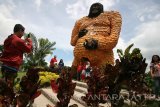 Sejumlah pengunjung berfoto di depan patung gorila raksasa yang terbuat dari jagung di area wisata Kampung Anggrek, Desa Sempu, Kediri, Jawa Timur, Minggu (22/1). Patung gorila raksasa setinggi 6 meter yang pembuatannya menghabiskan sebanyak 2,5 ton jagung tersebut guna menarik kunjungan wisatawan. Antara Jatim/Prasetia Fauzani/zk/17