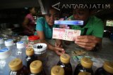 Petugas Bank Indonesia melakukan penyinaran uang kertas mengunakan sinar ultraviolet (UV) saat sosialisasi keaslian uang rupiah desain baru di hadapan pemilik warung makan di Desa Besuki, Kediri, Jawa Timur, Sabtu (7/1). Bank Indonesia melakukan sosialisasi tata cara mendeteksi uang asli sekaligus memperkenalkan uang rupiah desain baru secara langsung kepada masyarakat pedesaan. Antara Jatim/Prasetia Fauzani/zk/17