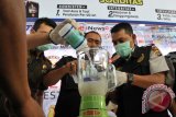 Kasat Narkoba Polresta Banda Aceh, Kompol Syafran ( tengah) bersama  petugas kejaksaan Kabupaten Aceh Besar, memasukan barang bukti tindak kejahatan narkotika jenis sabu ke dalam blender dicampur alkohol  saat pemusnahan di Banda Aceh, Rabu (1/2). Pemusnahan sabu sebanyak sekitar 500 gram itu merupakan barang bukti hasil tindak kejahatan narkotika yang berhasil diamankan dari seorang  tersangka berinisial AZ di bandara Sultan Iskandar Muda, Aceh Besar. (ANTARA Aceh/Ampelsa)