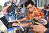 Seorang peserta memperbaiki robot ketika mengikuti lomba robot 'Line Follower' tingkat SMA/SMK se-Jawa Timur yang berlangsung di Universitas Narotama Surabaya, Jawa Timur, Kamis (2/2). Lomba robot 'Line Follower' dalam rangka Hari Jadi ke-36 Universitas Narotama diikuti 21 kelompok dari delapan sekolah yang berasal dari Surabaya, Malang dan Jember. Antara Jatim/M Risyal Hidayat/zk/17