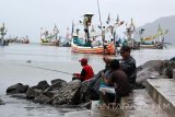 Sejumlah warga memancing di tepian dermaga Pelabuhan Muncar, Banyuwangi, Jawa Timur, Jumat (3/2). Nelayan setempat mengeluhkan hasil tangkapan ikan selama satu tahun terakhir menurun drastis, yang menyebabkan sebagian besar kapal slerek tidak melaut karena tidak mampu mencukupi biaya operasional kapal. Antara Jatim/Budi Candra Setya/zk/17