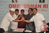 Dua pasangan calon Bupati-Wakil Bupati Buleleng pada Pemilihan Kepala Daerah (Pilkada) 2017 yaitu Dewa Nyoman Sukrawan (kedua kiri)-Gede Dharma Wijaya (kiri) dan Putu Agus Suradnyana (kedua kanan)-Nyoman Sutjidra (kanan) berjabat tangan disaksikan Kepala Ombudsman RI Perwakilan Bali, Umar Ibnu Alkhatab (tengah) seusai menandatangani pernyataan komitmen di Kantor Ombudsman RI Perwakilan Bali, Denpasar, Jumat (3/2). Kedua pasangan calon bupati-wakil bupati menyepakati untuk mewujudkan layanan publik berkualitas sesuai visi dan misi jika terpilih sebagai bupati-wakil bupati nanti. FOTO ANTARA/Nyoman Budhiana/i018/2017.