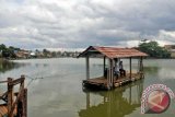 Warga memanfaatkan perahu 'eretan' untuk menyeberangi Situ Citayem yang menghubungkan dua desa diperbatasan Bogor dan Depok, Citayam, Kabupaten Bogor, Jawa Barat, Senin (30/1). Jasa penyeberangan eretan yang menghubungkan dua desa di perbatasan Depok dan Bogor masih bertahan sejak puluhan tahun untuk digunakan oleh warga sekitar untuk mempersingkat jarak dan waktu tempuh dengan ongkos sukarela antara Rp1.000 - Rp. 2.000 untuk sekali penyeberangan. (ANTARAFOTO/Yulius Satria Wijaya).