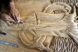 Pengrajin memproses kerajinan ukiran berbahan limbah kayu mebel di salah satu sentra di Talun, Blitar, Jawa Timur, Minggu (5/2). Ukiran berbagai motif yang dijual denga harga antara Rp.250 ribu hingga Rp.25 juta tergantung ukuran dan tingkat kesulitannya tersebut sudah dipasarkan hingga keberbagai kota besar seperti Jakarta, Bandung, Surabaya, Bali serta beberapa kota besar lainnya. Antara Jatim/Irfan Anshori/zk/17
