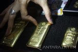 Seorang model menunjukkan aneka ukuran emas yang dijual dalam peluncuran gerai layanan penjualan emas Aneka Tambang (Antam) di Kantor Pos Malang, Jawa Timur, Senin (6/2). Dengan pembukaan gerai layanan penjualan emas tersebut diharapkan dapat memudahkan masyarakat dalam melakukan dan merencanakan investasi dengan emas batangan. Antara Jatim/Ari Bowo Sucipto/zk/17