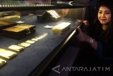 Seorang model menunjukkan aneka ukuran emas yang dijual dalam peluncuran gerai layanan penjualan emas Aneka Tambang (Antam) di Kantor Pos Malang, Jawa Timur, Senin (6/2). Dengan pembukaan gerai layanan penjualan emas tersebut diharapkan dapat memudahkan masyarakat dalam melakukan dan merencanakan investasi dengan emas batangan. Antara Jatim/Ari Bowo Sucipto/zk/17