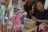 Perajin menyelesaikan pembuatan wayang kulit di kawasan Sukawati, Gianyar, Bali, Rabu (8/2). Kerajinan wayang kulit yang dijual dengan harga Rp75 ribu - Rp1 juta per buah tergantung ukuran dan kualitas tersebut dijual ke berbagai daerah di Bali, Sumatera dan Lombok. ANTARA FOTO/Fikri Yusuf/wdy/17