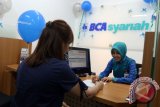 Petugas bank melayani nasabah di kantor BCA Syariah cabang Medan yang baru diresmikan, di Medan, Sumatera Utara, Selasa (7/2). Kantor BCA Syariah yang baru diresmikan tersebut merupakan kantor cabang utama pertama di Pulau Sumatera. ANTARA SUMUT/Irsan Mulyadi/17