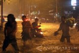 Seorang pengendara sepeda motor menerobos banjir di Depan Kantor Pemerintah Banyuwangi, Jawa Timur, Kamis (10/2). Hujan lebat yang mengguyur kawasan itu, mengakibatkan banjir di beberapa ruas jalan setinggi lutut orang dewasa yang mengganggu pengguna jalan. Antara Jatim/Budi Candra Setya/zk/17