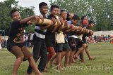 Sejumlah anak berusaha memegangi bambu saat bermain Bambu Gila di Kota Madiun, Jawa Timur, Minggu (5/2). Seni tradisional asal Maluku tersebut digelar kelompok pekerja seni untuk memberi hiburan bagi warga Madiun. Antara Jatim/Siswowidodo/zk/17
