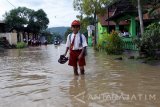 Siswa berjalan menerjang banjir di Kecamatan Sutojayan, Blitar, Jawa Timur, Senin (13/2). Banjir yang disebabkan tingginya curah hujan didaerah tersebut sejak Minggu (12/2) malam mengakibatkan 710 rumah di empat desa  terendam, serta sejumlah sekolah terpaksa menghentikan aktifitas belajar mengajar. Antara Jatim/Irfan Anshori/zk/17