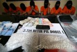 Polisi menunjukan sejumlah barang bukti di antaranya pil koplo atau pil dobel L sebanyak 2.718 butir berikut tersangka pengedar saat rilis penyalah gunaan narkoba di Polresta Kediri, Jawa Timur, Selasa (14/2). Peredaran pil koplo di wilayah tersebut dalam taraf mengkawatirkan terbukti dari hasil ungkap jajaran kepolisian dengan rata-rata barang bukti yang diamankan sejumlah ribuan butir dalam setiap bulannya. Antara Jatim/Prasetia Fauzani/zk/17
