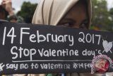 Siswa SMP Muhammadiyah 2 Surabaya memegang poster saat mengikuti aksi stop peringatan Hari Valentine di Surabaya, Jawa Timur, Senin (13/2/2017). Mereka mengajak masyakat untuk tidak merayakan Hari Valentine yang diperingati setiap 14 Februari tersebut karena dinilai bukan budaya Indonesia. (ANTARA /Zabur Karuru)