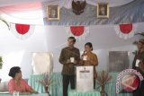 Presiden Joko Widodo (kedua kiri) dan Istri, Iriana Widodo (kedua kanan) menunjukkan surat suara saat menggunakan hak suara dalam Pilkada DKI Jakarta di TPS 04 Gambir, Jakarta, Rabu (15/2). Komisi Pemilihan Umum (KPU) menggelar pemilihan umum kepala daerah secara serentak di 101 daerah pemilihan. ANTARA FOTO/Rosa Panggabean/wdy/17.