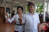 Calon Independen Pilkada Buleleng, Dewa Nyoman Sukrawan (kanan) bersama istrinya menggunakan hak pilihnya di Tempat Pemungutan Suara (TPS) 9 Desa Bungkulan, Buleleng, Bali, Rabu (15/2). Pilkada Buleleng diikuti oleh dua pasangan calon yakni calon pertahanan Putu Agus Suradnyana-Nyoman Sudjidra dan calon independen Dewa Nyoman Sukrawan-Gede Dharma Wijaya dengan jumlah daftar pemilih tetap sebanyak 583.381 jiwa yang tersebar di 1.086 TPS. ANTARA FOTO/Wira Suryantala/17.