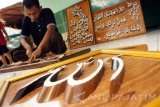 Pecinta seni kaligrafi merangkai kaligrafi tulisan Arab menggunakan bahan limbah pucuk bambu di Tulungagung, Jawa Timur, Rabu (15/2). Kerajinan kaligrafi berbahan limbah bambu itu dijual mulai Rp125 ribu hingga Rp1 juta per-buah, menyesuaikan ukuran dan tingkat kerumitan kaligrafi yang dibuat, dengan metode pemasaran secara daring atau online. Antara Jatim/Destyan Sujarwoko/zk/17