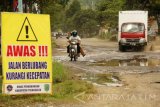 Sejumlah kendaraan melintasi genangan air di jalan poros Trenggalek-Tulungagung yang mengalami kerusakan di ruas Desa Ngetal, Trenggalek, Jawa Timur, Jumat (17/2). Pemerintah mengalokasikan anggaran sebesar Rp18 miliar untuk memperbaiki kerusakan jalan nasional penghubung di ruas Kertosono-Jarakan, Trenggalek degan panjang sekitar 120 kilometer. Antara Jatim/Destyan Sujarwoko/zk/17