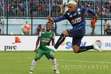 Pesepakbola Arema FC, Cristian Gonzales (kanan) menendang bola ke arah gawang PS TNI setelah lolos dari hadangan pesepakbola Muhammad Abduh Lestaluhu dalam pertandingan Piala Presiden Grup 2 di Stadion Kanjuruhan, Malang, Jawa Timur, Kamis (16/2). Dalam pertandingan tersebut Arema unggul atas PS TNI dengan skor akhir 4-0. Antara jatim/Ari Bowo Sucipto/zk/17.