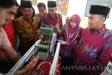 Menteri Pendidikan dan Kebudayaan (Mendikbud) Muhadjir Effendy (kanan) didampingi Wakil Bupati Nganjuk Abdul Wachid Badrus (tengah) mengamati prototipe generator hasil karya pelajar SMK saat menghadiri pembukaan rapat koordinasi nasional (rakornas) Ikatan Bimbingan Konseling Sekolah (IBKS) di Nganjuk, Jawa Timur, Sabtu (18/2). Rakornas IBKS yang dihadiri 658 guru bimbingan konseling dari 29 provinsi tersebut guna melantik pengurus IBKS tingkat provinsi seluruh Indonesia. Antara Jatim/Prasetia Fauzani/zk/17