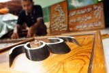 Pecinta seni kaligrafi merangkai kaligrafi tulisan Arab menggunakan bahan limbah pucuk bambu di Tulungagung, Jawa Timur, Rabu (15/2). Kerajinan kaligrafi berbahan limbah bambu itu dijual mulai Rp125 ribu hingga Rp1 juta per-buah, menyesuaikan ukuran dan tingkat kerumitan kaligrafi yang dibuat, dengan metode pemasaran secara daring atau online. Antara Jatim/Destyan Sujarwoko/zk/17